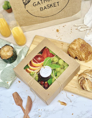 Colorful fruit box, 3 pastries and 2 stemless glasses of orange juice